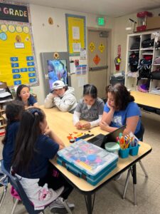 Students participating in a hands-on learning center at SNACS.